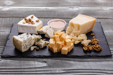 set of different cheeses on a wooden rustic background.の写真素材