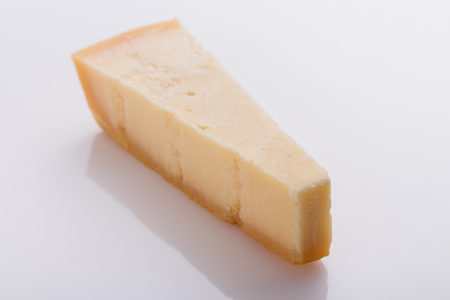 A fragrant parmesan piece on a white acrylic background.の写真素材