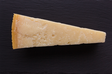 Parmesan slice on a stone slate plate.の写真素材