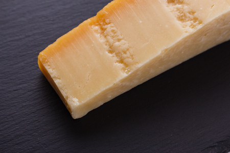 Parmesan slice on a stone slate plate.の写真素材