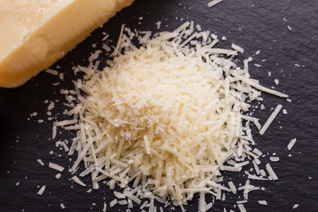 fragrant grated Parmesan on a slate stone slicing board.