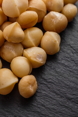 delicious macadamia nuts on a dark stone background.の写真素材