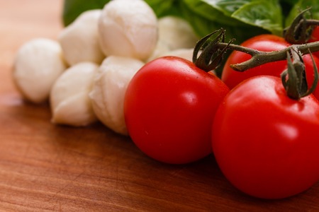 Mozzarella tomatoes and basil on a wooden rustic background.の写真素材