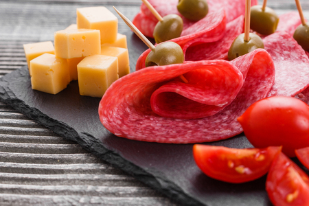 delicious sliced salami on a stone plate.の写真素材
