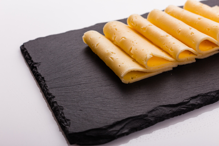 Piece and slices of cheese on a white background.の写真素材