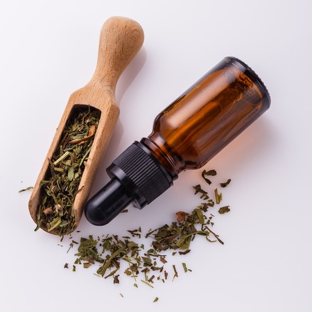 dried tarragon and essential oil on a white background.の写真素材