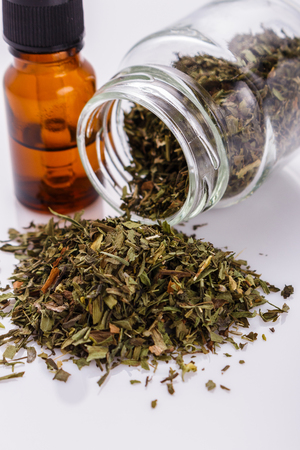 dried tarragon and essential oil on a white background.の写真素材