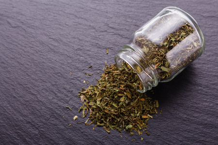 dried tarragon and essential oil on a dark stone background.の写真素材