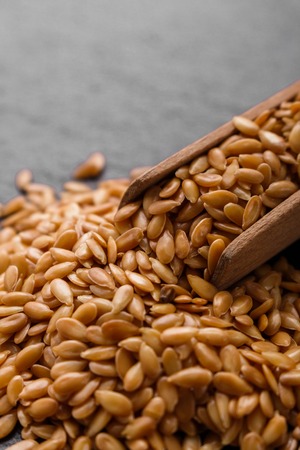 seeds of golden flax on a dark stone background.の写真素材
