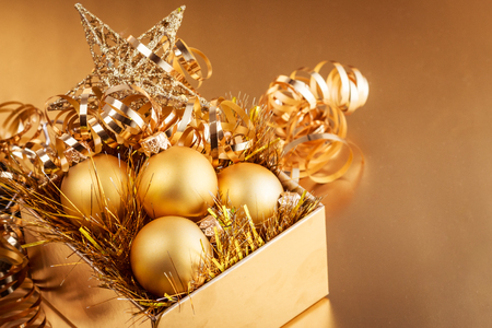 Christmas composition of Christmas tree toys on a blurred gold background.の写真素材
