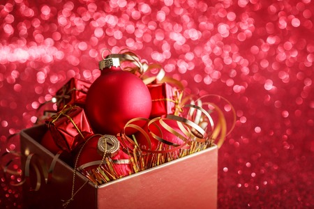 Christmas composition of Christmas tree toys on a blurred red background.の写真素材