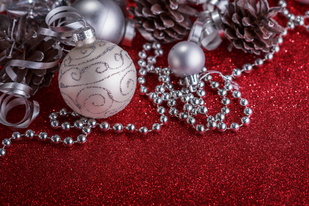 Christmas composition of Christmas tree toys on a blurred red background.の写真素材