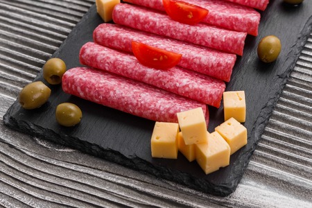 delicious sliced salami on a stone plate.