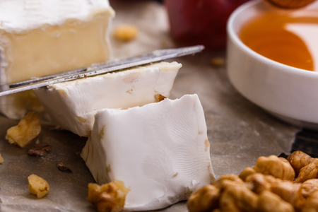 delicious creamy camembert cheese on a wooden rustic background.の写真素材