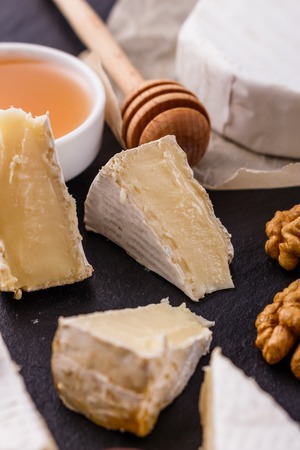 delicious creamy camembert cheese on a wooden rustic background.の写真素材