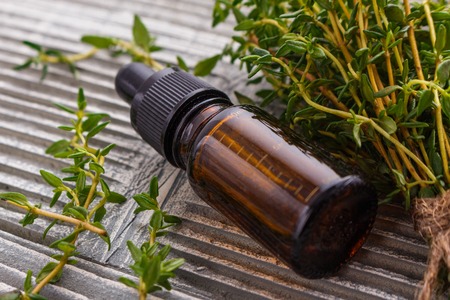 essential oil of thyme on a gray wooden rustic background.の写真素材
