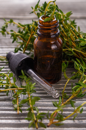 essential oil of thyme on a gray wooden rustic background.の写真素材