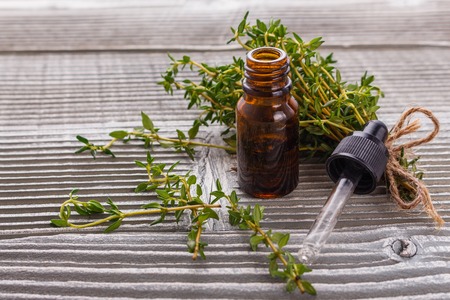 essential oil of thyme on a gray wooden rustic background.の写真素材