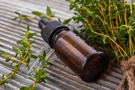 essential oil of thyme on a gray wooden rustic background.の写真素材