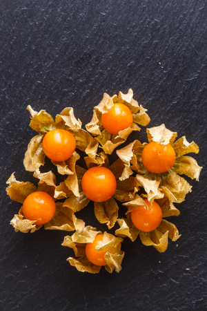 juicy winter cherry on a dark stone background.の写真素材