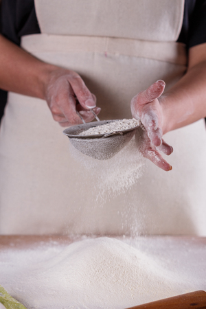 young woman squirting a flour in an apron.の写真素材