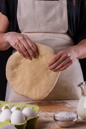 young woman wearing a duck on a wooden board in an apron.の写真素材