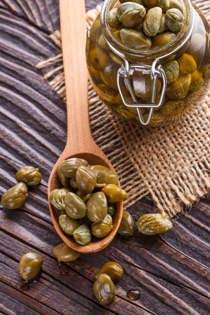 pickled capers on a wooden rustic background.の写真素材
