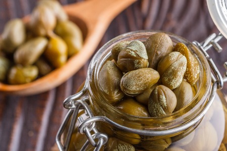 pickled capers on a wooden rustic background.の写真素材