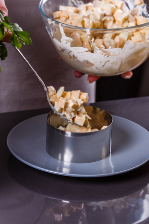young woman in a gray aprons preparing Hawaiian salad.の写真素材