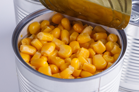 Canned corn in a iron can on white background.の写真素材