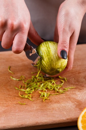 young woman in a gray aprons cut cedar lime.の写真素材