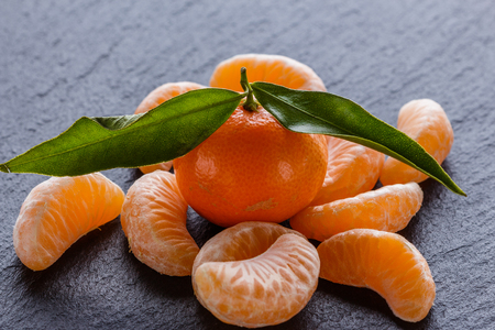 juicy mandarin on a dark stone background.の写真素材
