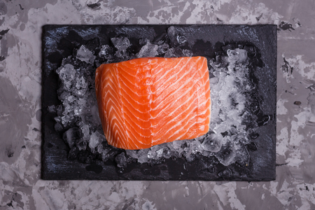 chilled salmon fillet on a black stone plateの写真素材