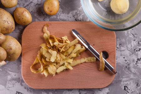 Peeled potato skin on chopping boardの写真素材