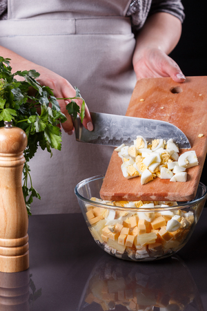 young woman in a gray aprons preparing Hawaiian salad.の写真素材