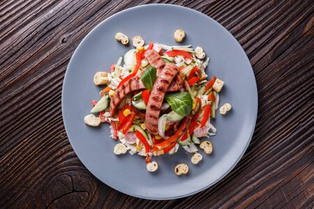 Salad with grilled sausage paprica cucumber and croutons.の写真素材
