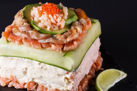 Piece of traditional savory swedish sandwich cake Smorgastorta with a caviar, mayonnaise, cucumber, square formatの写真素材