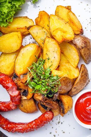 baked potatoes with sausages on a wooden rustic background.の写真素材
