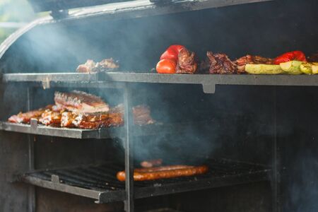 meat and vegetables in large BBQ grill at street food festival.の写真素材