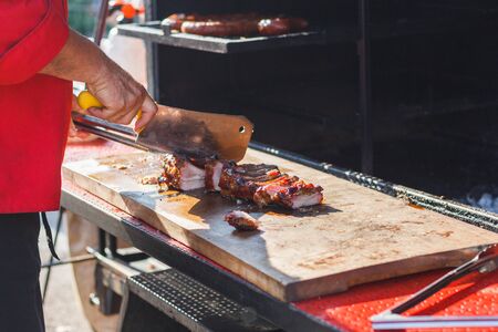 chef cooks ribs at the street food festival.の写真素材