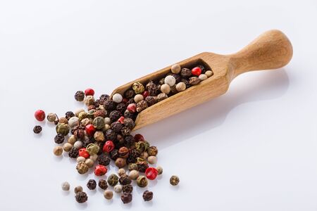 mix of peppercorns on white acrylic background.