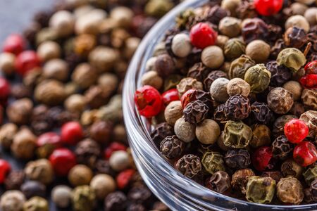 mix of peppercorns on a dark stone background.の写真素材
