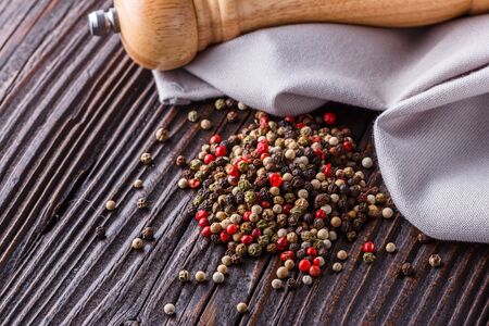 mix of peppercorns on a dark wooden rustic background.