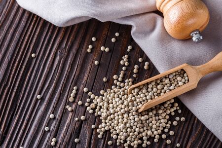 white peppercorns in wooden scoop on rustic background.の写真素材