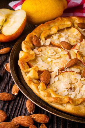 crispy apple galette with almonds on rustic wooden background.の写真素材