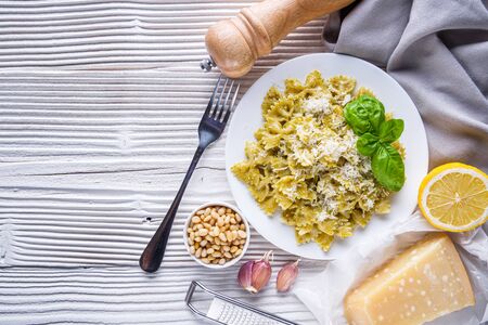 Delicious farfalle pasta with pesto sauce on wooden rustic background.の写真素材