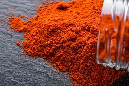 aromatic ground paprika on a dark stone background.