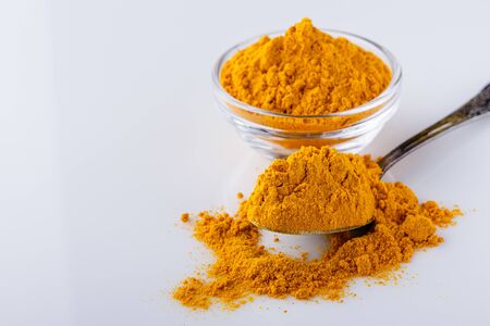 natural turmeric powder on white acrylic background.