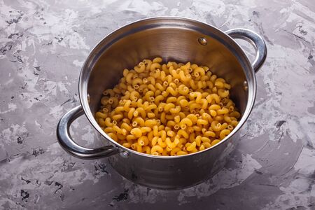 Traditional Italian pasta in a metal pan on a stone background.の写真素材