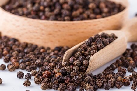 fragrant black pepper on white acrylic background.